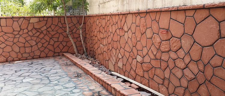 نصب و اجرای سنگ لاشه و سنگ مالون طبیعی قرمز رنگ برای نمای دیوار حیاط سازی ساختمان اجرا شده است  